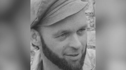 Black and white picture of Michael Eavis in 1970 wearing a flat cap.