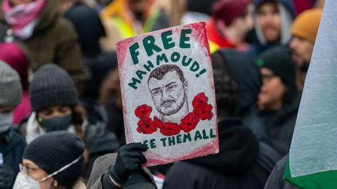 A person holds a sign saying 'Free Mahmoud!' at a demonstration in support of Mahmoud Khalil in Times Square in New York in April