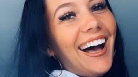 Kiena Dawes close up photo of her laughing - with long dark hair and a silver hoop earring