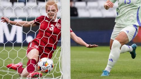 Denmark attempt to clear the ball heading for goal