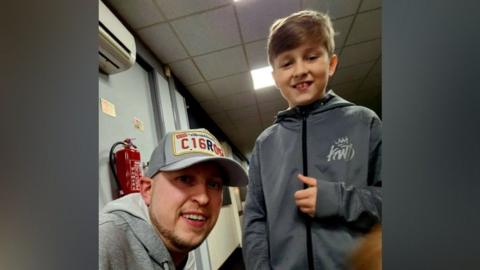 Josh Slater in a grey cap sat next to his brother Keaton, wearing a grey jacket