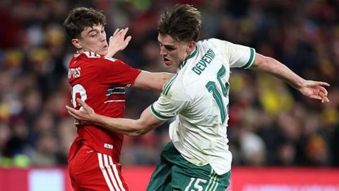 Daniel James of Wales battles for possession with Justin Devenny of Northern Ireland