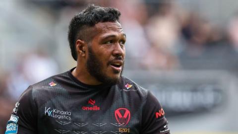 Agnatius Paasi is wearing a black St Helens top and is looking to his left.