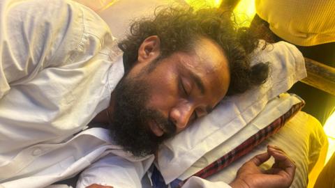 Devendra Nath Mahto lying on a mattress while he was on a hunger strike