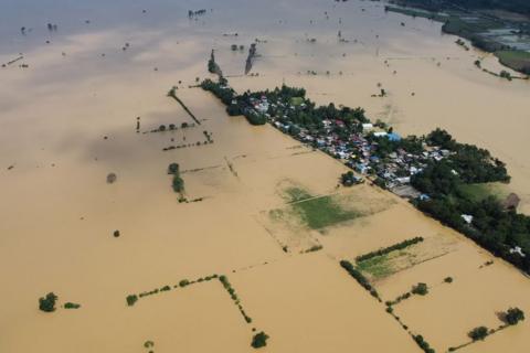 An aerial photo shows a swollen river inundating farm fields and houses at a village in Ilagan town, Isabela province on November 12, 2024, a day after Typhoon Toraji hit the province of the northern Philippines.