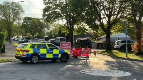 A police car in front of a road closed sign in Southway.