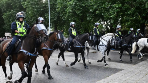 Several police officers on horses.