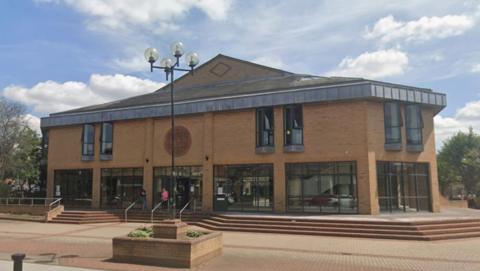 Lincoln Magistrates' Court building. The sky is blue with clouds.