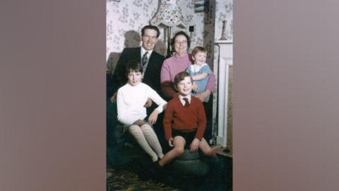 Karlis Zirins sitting with his wife and three children at home in about 1967