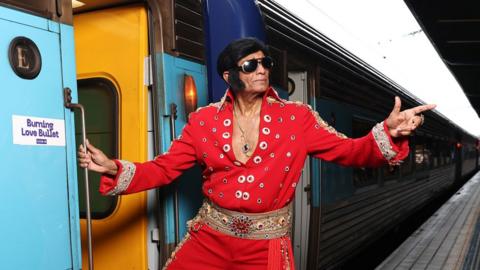 Elvis impersonator Alfred Vaz poses prior to  boarding a train departing for Parkes Elvis Festival at Sydney Central Station on January 09, 2025 in Sydney, Australia