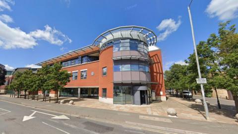 A view of the front of Worcester Magistrates ' Court from the street. It is a brick building with a glass entrance. 