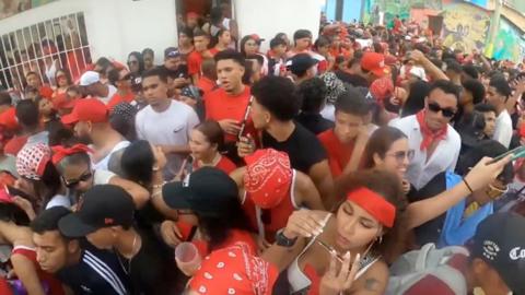People in red in a tight crowd.