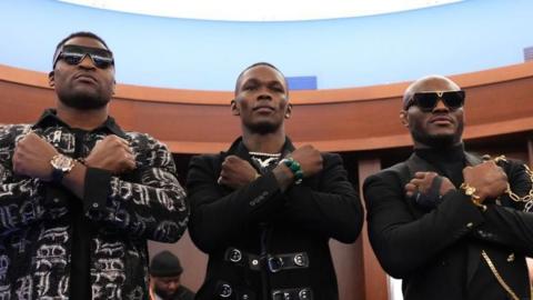 Francis Ngannou, Israel Adesanya and Kamaru Usman all make an X with their arms