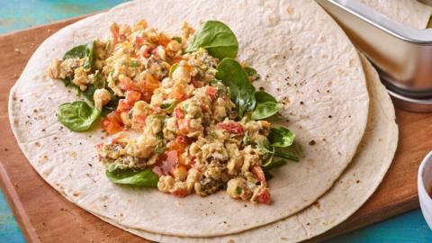 An open wrap filled with chickpeas, spinach and red peppers