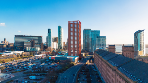 Image shows the dock road in Liverpool, with a superimposed artist's impression of the King Edward Tower, which will rise to 28 storeys. The historic Waterloo warehouse building is in the foreground. 