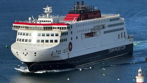 The Manxman ferry, which is white, red and black and has Steam-Packet.com on the side, entering Douglas Harbour.
