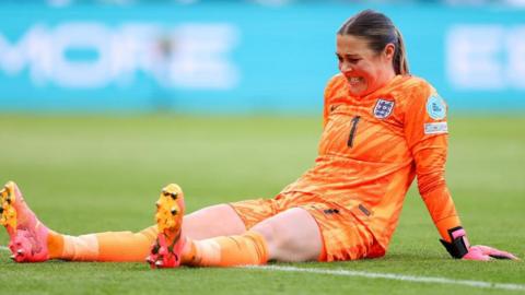 Mary Earps lays on the pitch with a hip injury