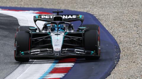 Mercedes' George Russell goes over a kerb during Austrian Grand Prix first practice