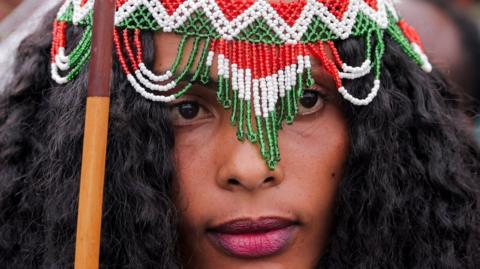 A woman dressed in a traditional Oromo costume attends the Irreecha celebration, the Oromo people's thanksgiving festival at Hora Arsadi in Bishoftu.