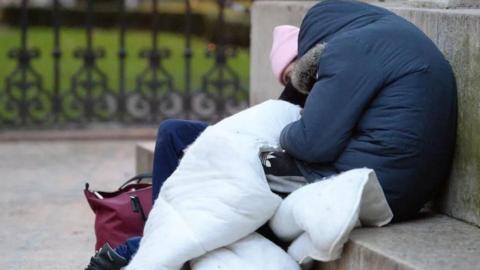 Two homeless people on a bench