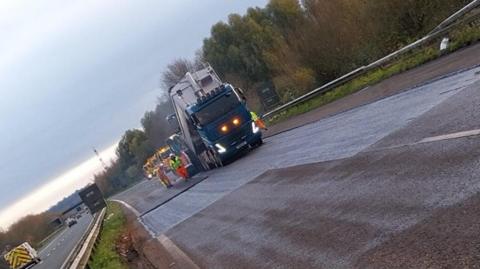 A lorry and workmen on a motorway