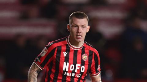 Kacpar Lopata in the red and black stripes of loan club Walsall
