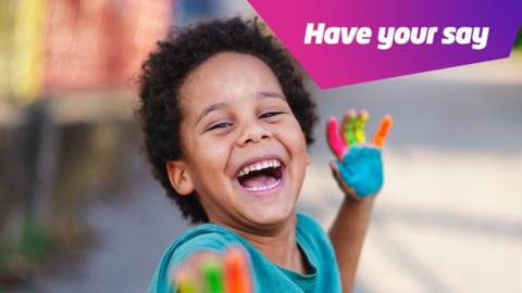 smiling boy with paint on his hands. 