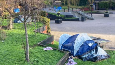 Tents pitched up on the grass in the middle of the Bear Pit roundabout in Bristol