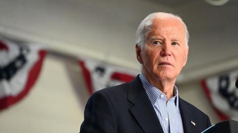 Joe Biden looking off to the side, standing at a podium