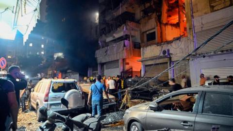 People gather in front of a damaged building after an Israeli military strike at the Nuwayri area in Beirut, Lebanon, 10 October 2024. 