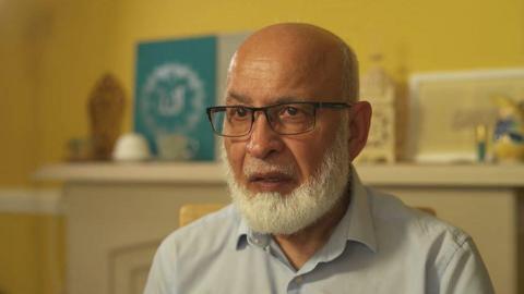 Mohammad Rasul staring to the left of the camera sat in his home talking to the 鶹Լ