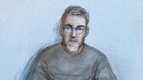 A court drawing of Mr San Diego. He is wearing round glasses and a grey tracksuit