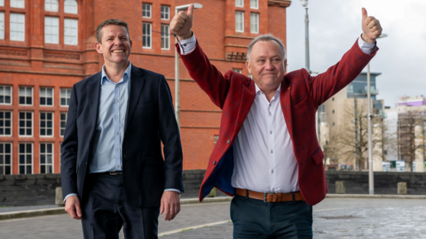 Lindsay Whittle with a double thumbs up as he walks into the Senedd with Plaid Cymru leader Rhun ap Iorwerth