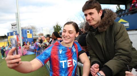 Aniek Nouwen of Crystal Palace poses for a photo with a supporter after the team's victory against Aston Villa.