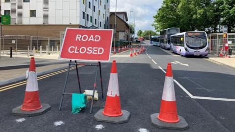 Traffic cones and a road closed sign on one side of Vicar Lane