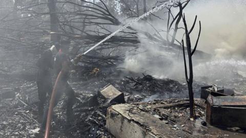Firefighters tackle debris after plane crash