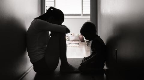 A woman and child sitting on the floor