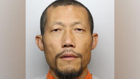 Police mugshot of Hongchi Xiao looking into the camera