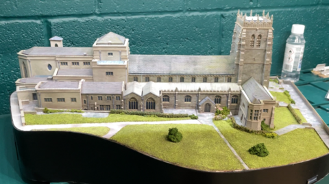 A model of Bradford Cathedral with miniature green lawns surrounding the main buildings 