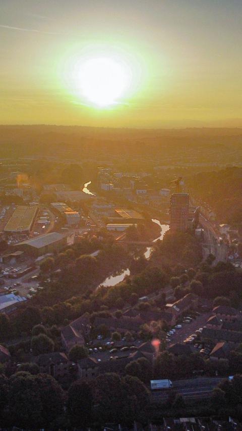 An aerial photograph of Bristol at dawn with the sun on the horizon