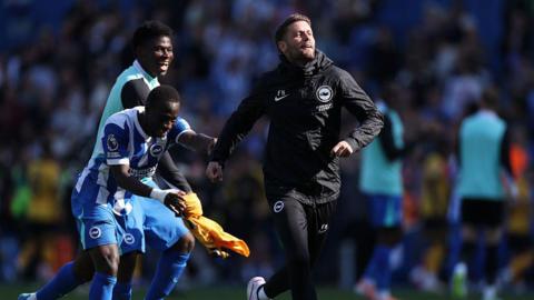 Yankuba Minteh and Carlos Baleba push Fabian Hurzeler towards the supporters to celebrate