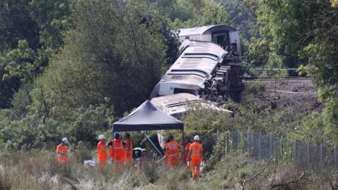 People in orange at scene of East Sussex train derailment