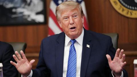 US President Donald Trump raises both his hands while speaking during a Cabinet meeting at Camp David in Maryland on 31 July