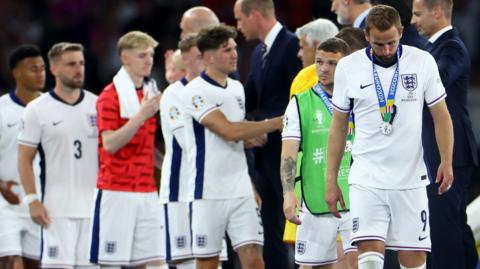 Harry Kane leads a line of England players collecting runners-up medals after the Euro 2024 final