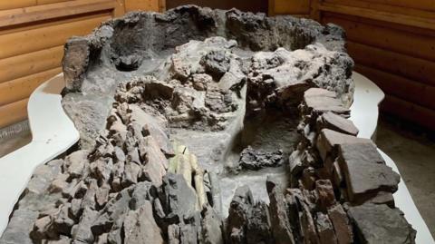 A close-up of the ancient Roman pottery kiln with eroded stone and brick walls, showing a weathered, sunken structure used for high-temperature firing.