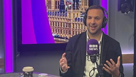 Zack Polanski is sitting in a studio behind a mic saying "BBC News" 