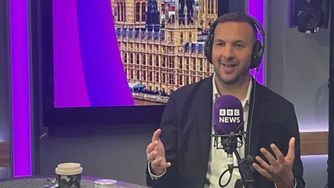 Zack Polanski is sitting in a studio behind a mic saying "BBC News" 