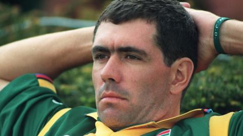 Hansie Cronje with her hands behind his head