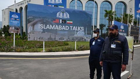 Private security personnel stand at the media centre ahead of USIran peace talks in Islamabad.