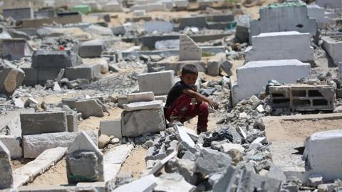 Palestinians, including children inspect the site after an Israeli airstrike severely damaged the Al-Ansar Mosque and partially destroyed the surrounding cemetery in Deir al-Balah, located in the central Gaza Strip on June 03, 2025